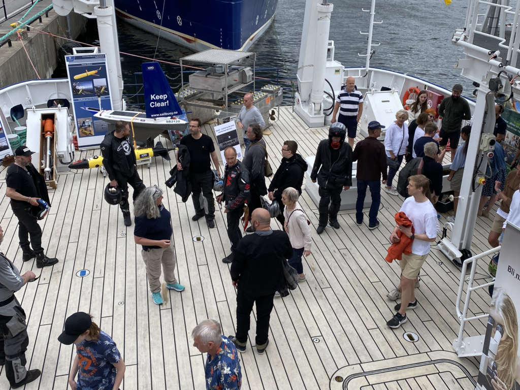 Visitors from the general public are guided onboard R/V Skagerak during 'Open Ship' in Stockholm in June 2022. Visitors were shown autonomous platforms, including the Sailbuoy and the Seacat.